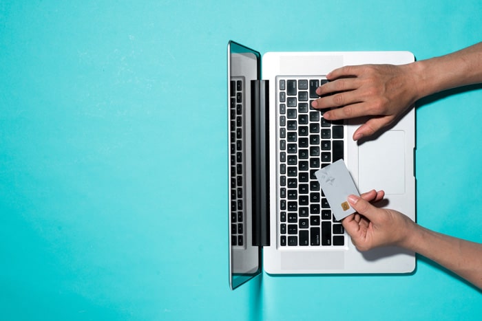 Person on laptop with bank card